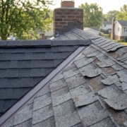 Close-up comparison of new vs damaged asphalt shingles on a Mid-Missouri residential roof