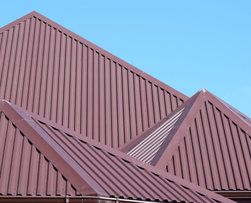 Red metal roofing on a peaked roof.