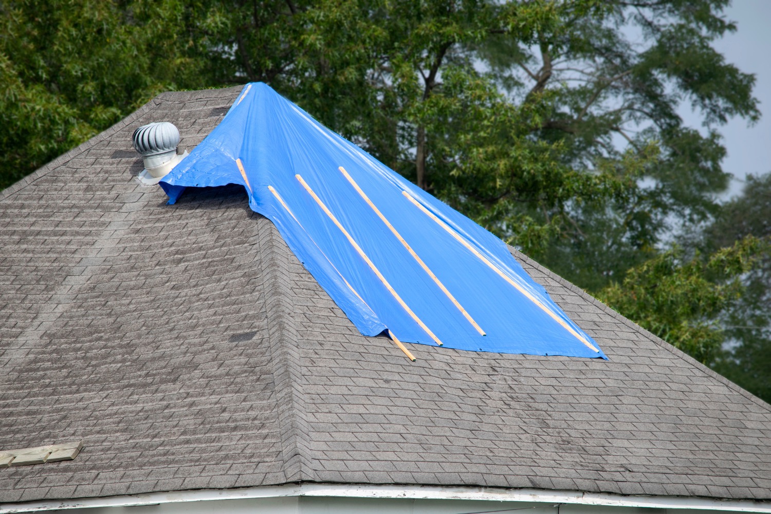 Mid Mo roof damage with blue tarp for protection.