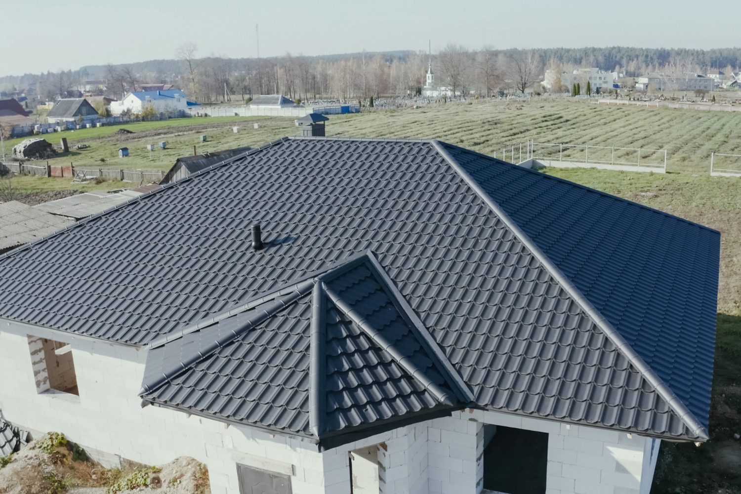 New construction home with black tile roofing.