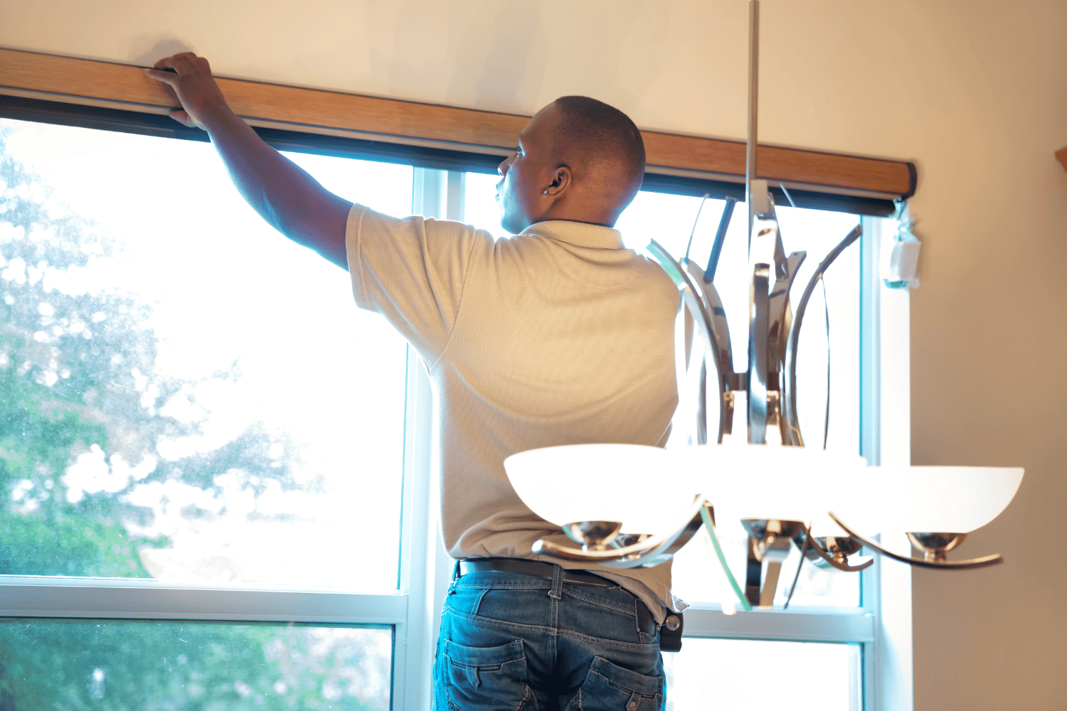 A person securing and insulating a newly installed window, focusing on the finishing touches of window installation.