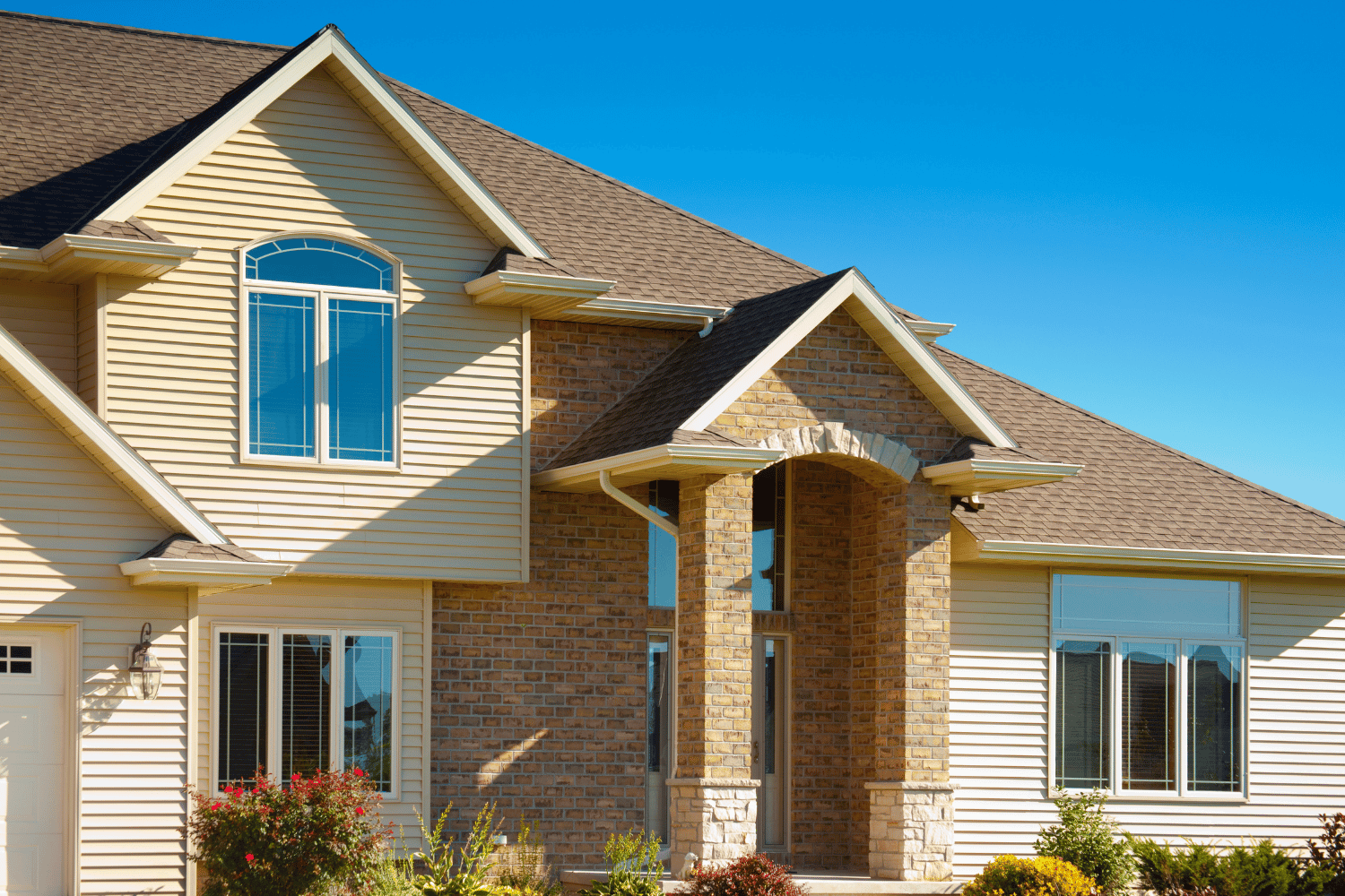 An illustration of a home exterior featuring vinyl siding with stone accents. 