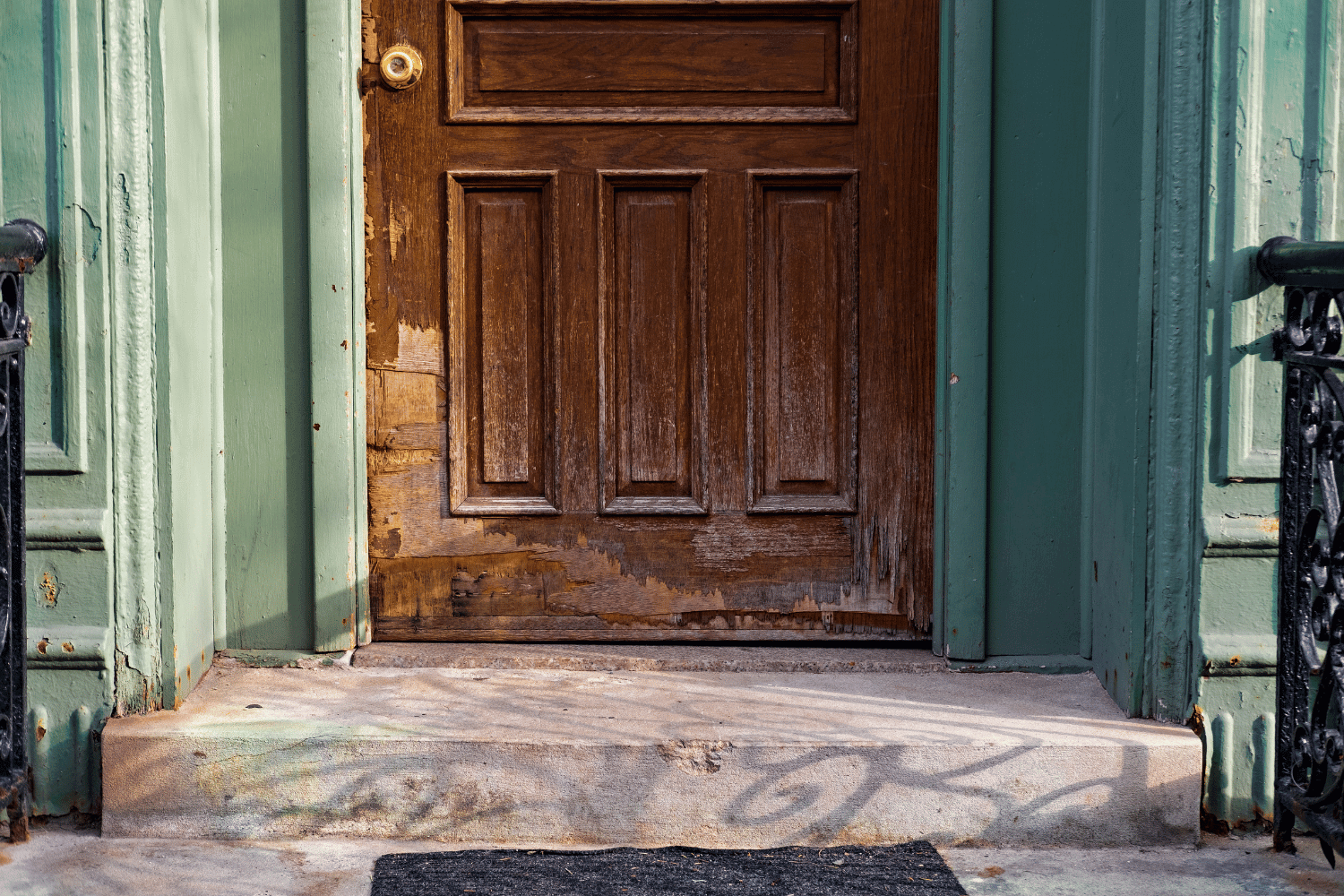 A front door showing signs of damage and wear, indicating a need for repair. 