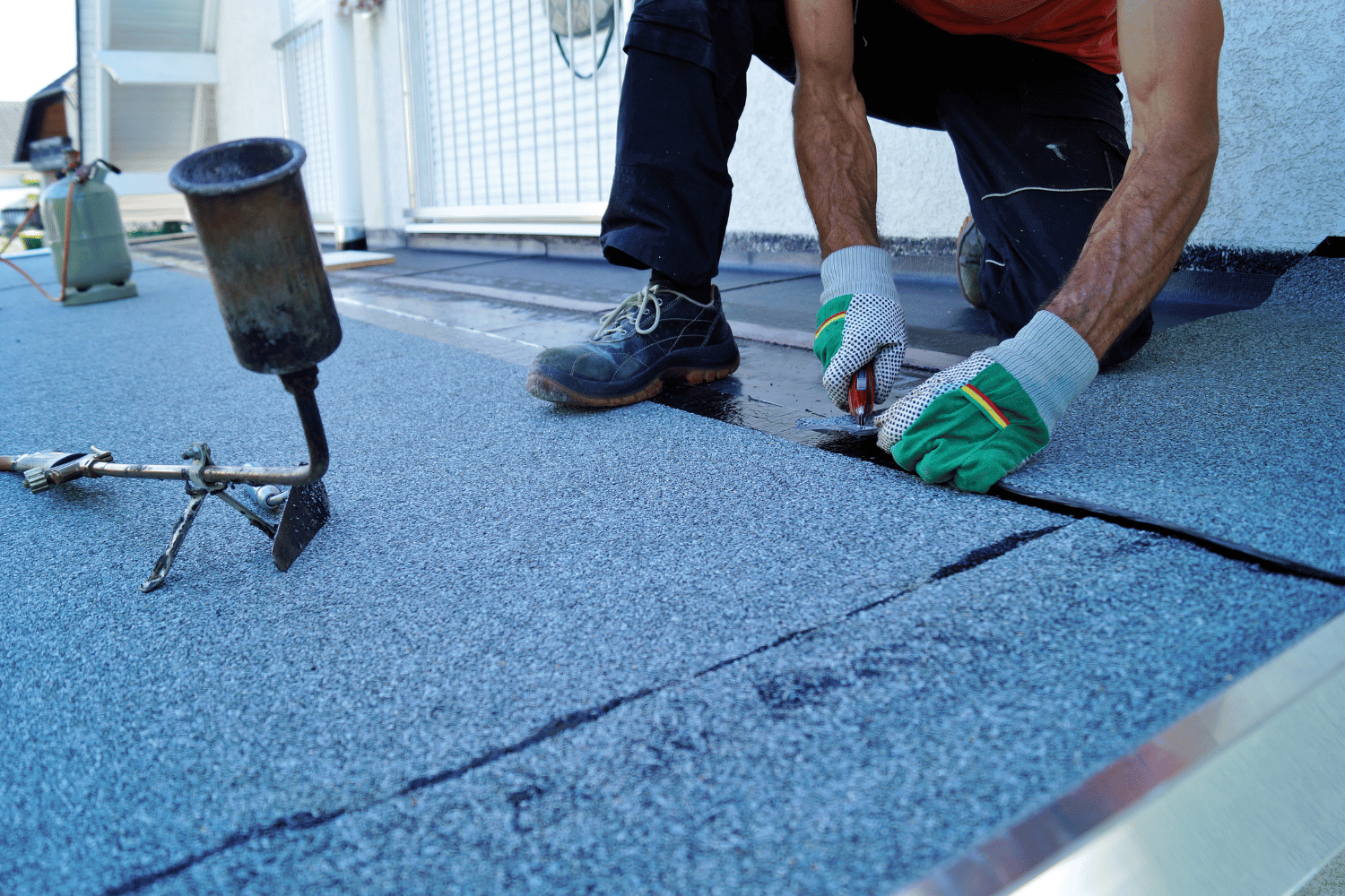 A maintenance worker inspecting a TPO roof for signs of wear. 