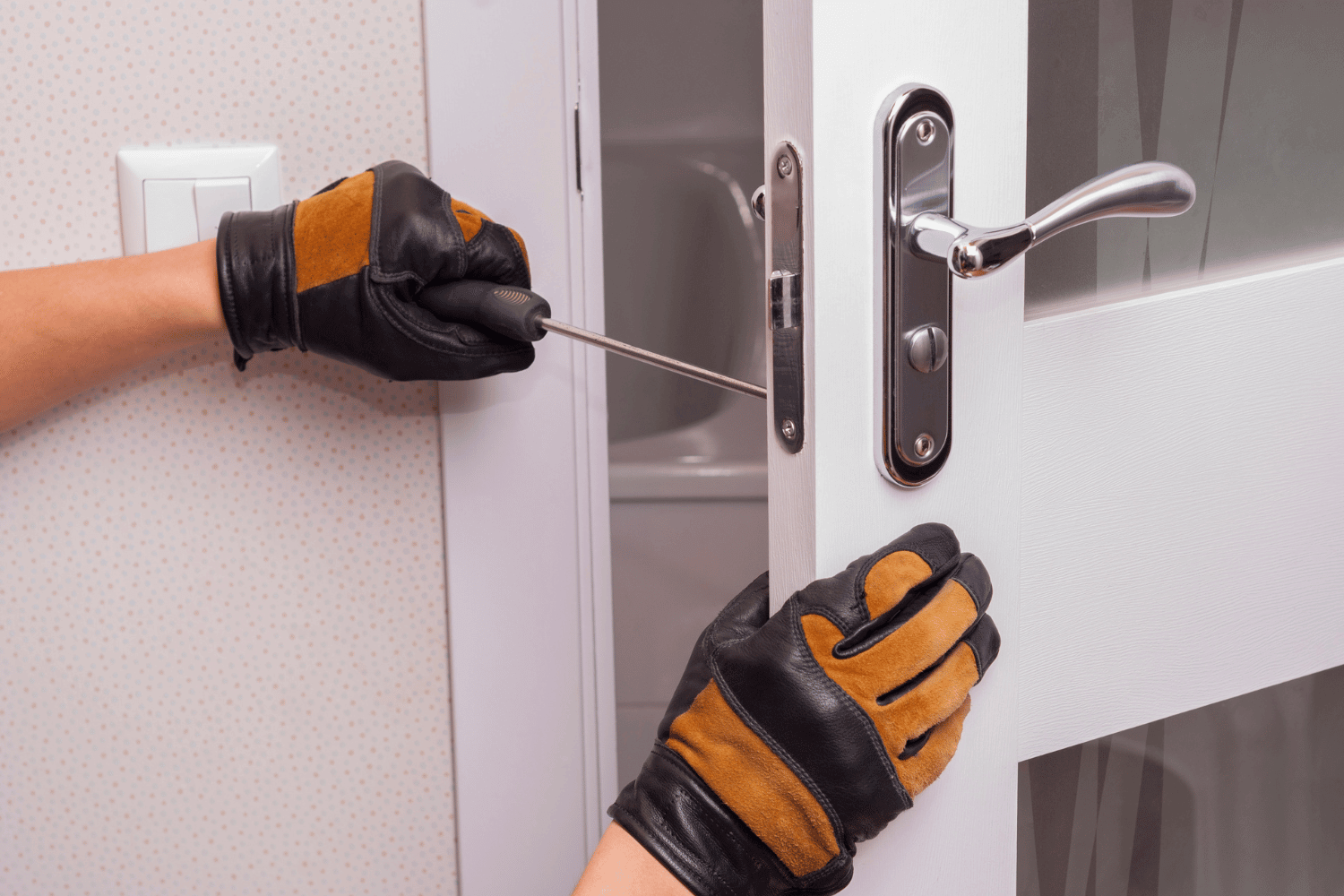 A technician performing a door repair, focusing on lock and handle adjustments. 