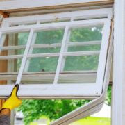 A person preparing for window replacement with tools and materials laid out.