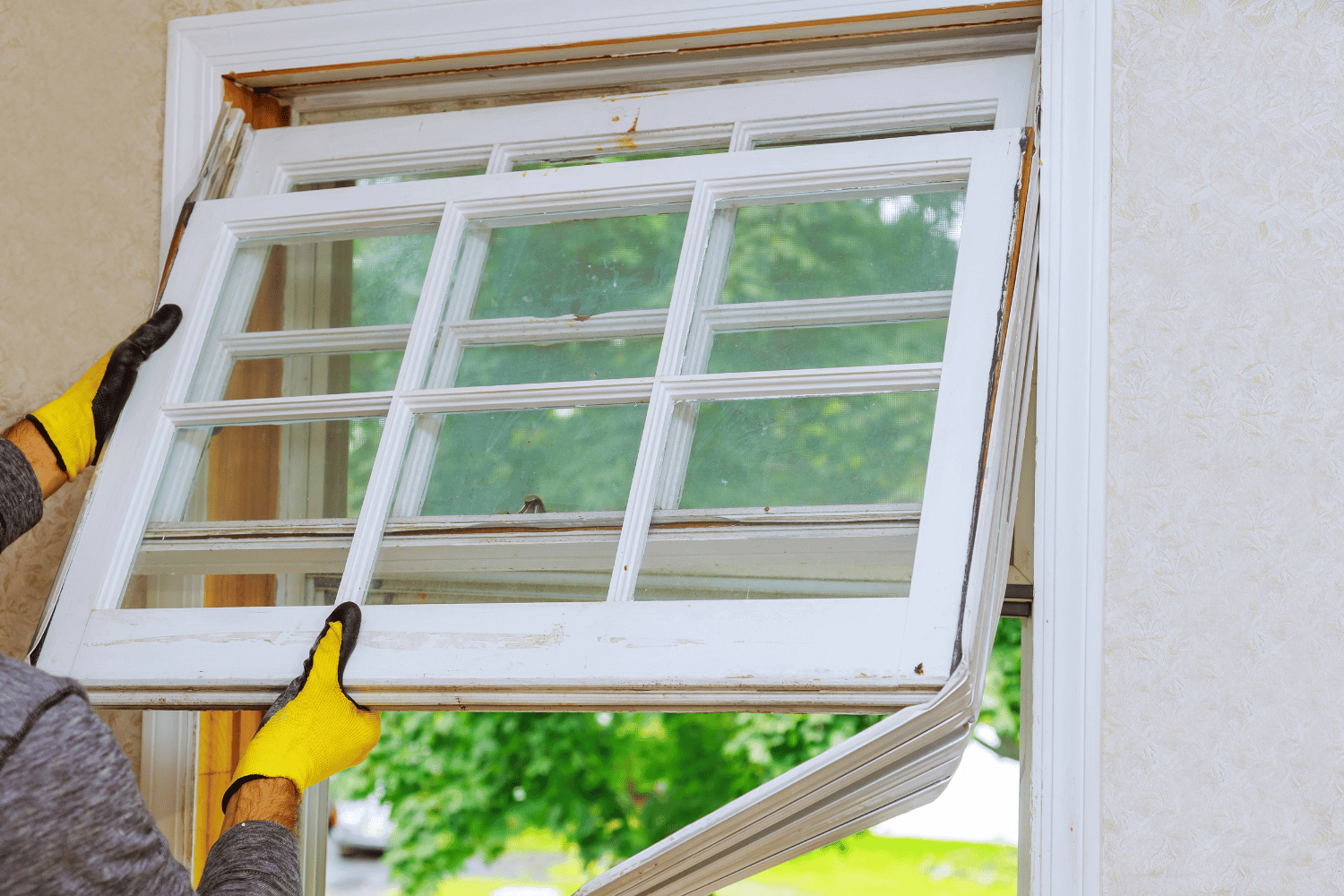 A person preparing for window replacement with tools and materials laid out. 