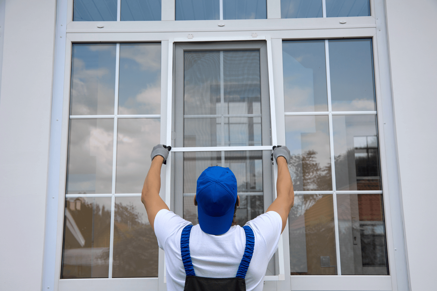 A person removing an old window frame from a house. 