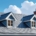 Modern gabled roof with chimneys and dormer windows against a cloudy blue sky