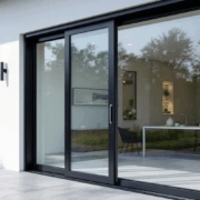 The image depicts the installation of modern energy-efficient sliding glass doors, showcasing their aesthetic appeal and functionality. The new patio doors enhance natural light and provide easy access to the backyard, while also contributing to energy efficiency and security for homeowners.