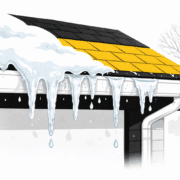 A close-up view of a residential roof's edge features icicles hanging from the gutters, with ice forming due to cold weather and melting snow. This scene illustrates the effects of winter weather on roofing materials, emphasizing the importance of proper installation to prevent ice dam formation and potential roof damage.